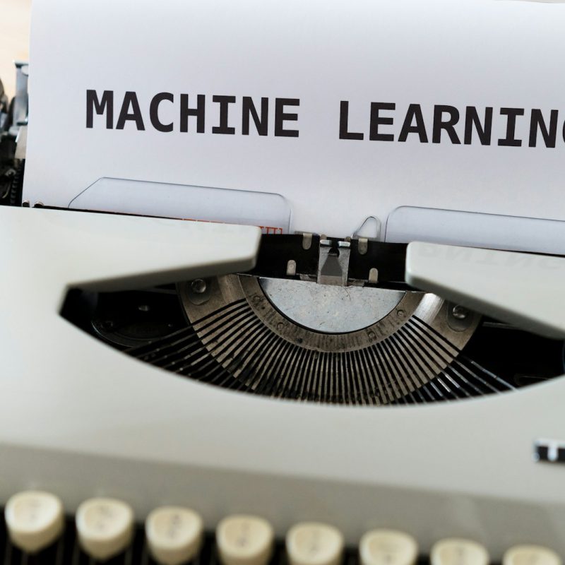 a close up of a typewriter with a paper reading machine learning